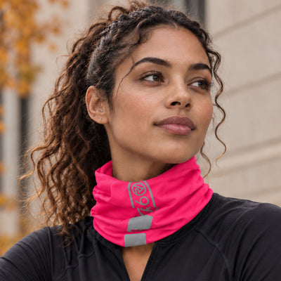 lifestyle A woman wearing a bright pink Proviz athletic neck gaiter with reflective gray stripes and a teal logo, paired with a black athletic top.